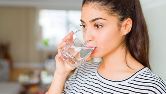 Woman drinking water to be healthy under the guidance of San Francisco chiropractor